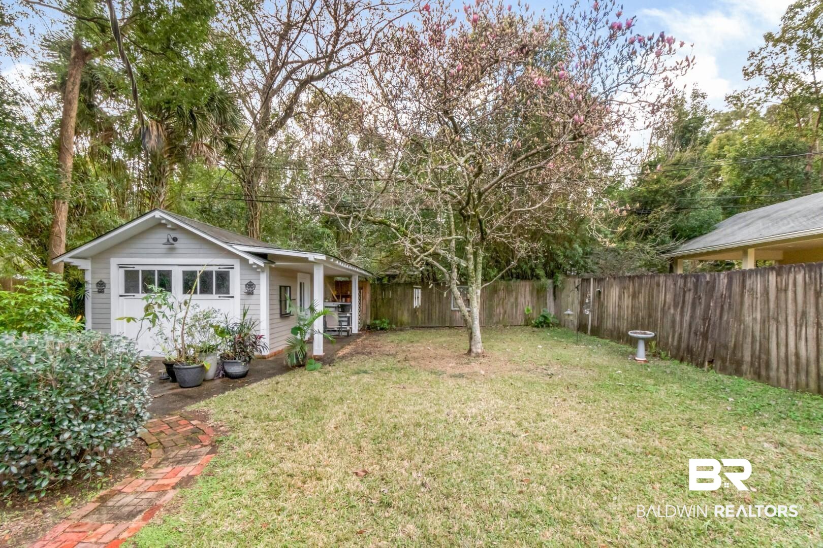 135 Silverwood Street Mobile, AL 36607 - Photo 24 of 32 Fenced backyard with covered porch and view of scattered trees