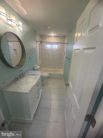 a bathroom with a sink mirror vanity and toilet