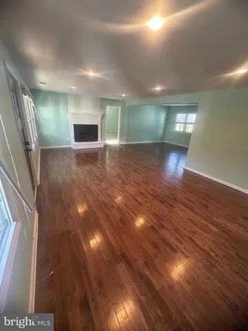 an empty room with wooden floor and entrance