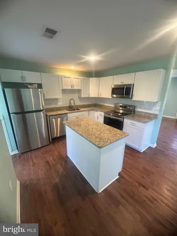 a kitchen with stainless steel appliances granite countertop a refrigerator a stove top oven a sink and dishwasher