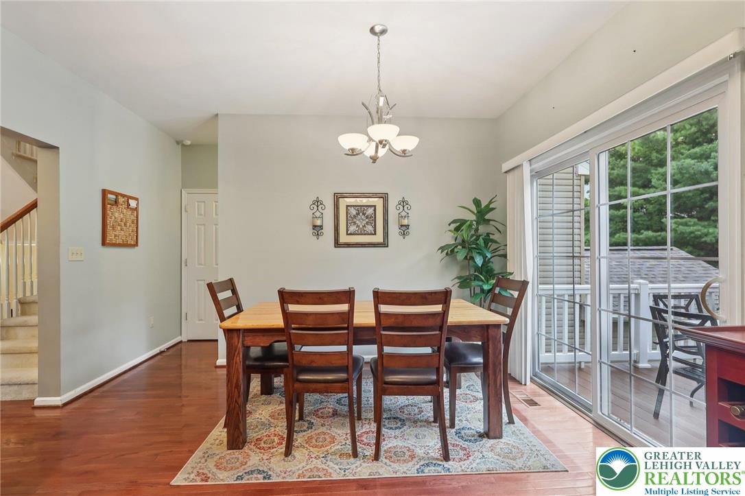 5192 Spring Ridge Drive East Macungie, PA 18062 - Photo 8 of 22 a dining room with wooden floor a chandelier a wooden table and chairs