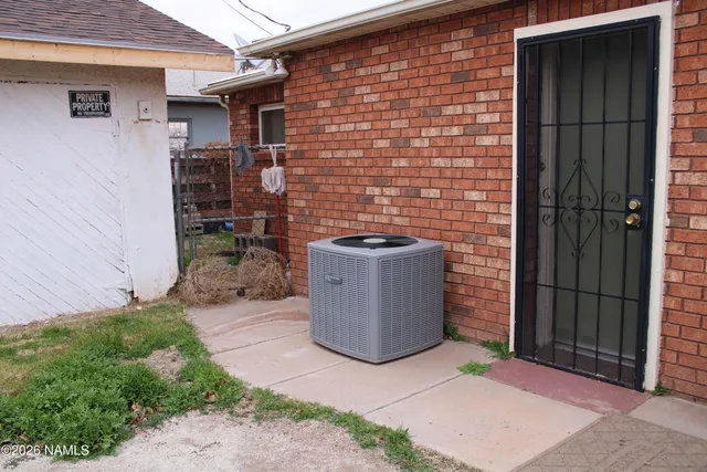 an empty room with wooden floor closet and windows