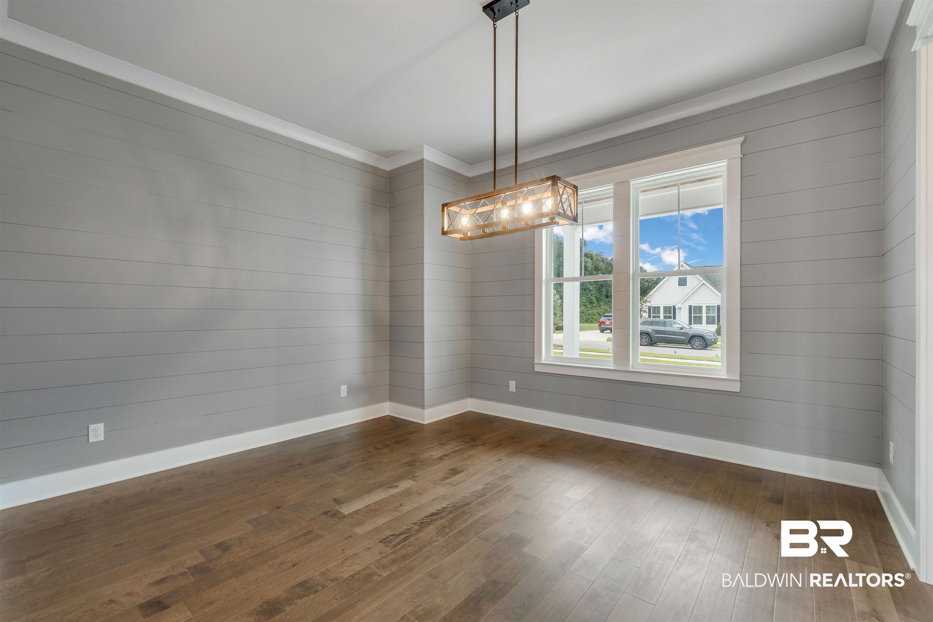 10985 Atrium Avenue Fairhope, AL 36532 - Photo 18 of 58 Unfurnished dining area with dark wood-style flooring, wooden walls, and crown molding