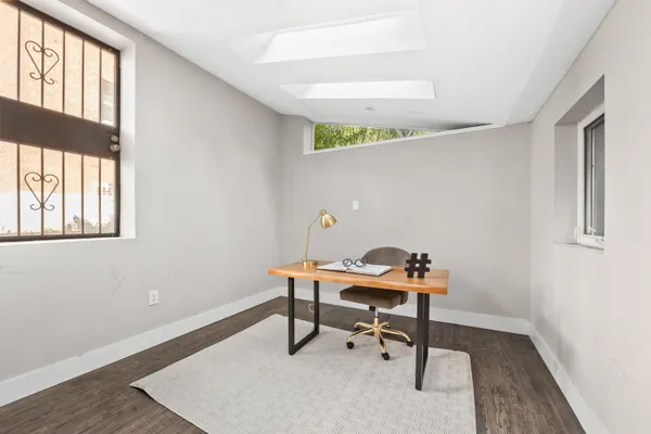 a view of a workspace with furniture and a window