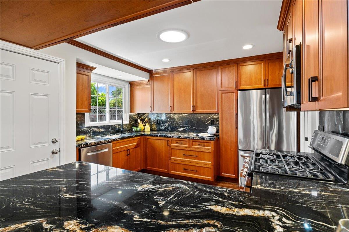 3530 Casanova Drive San Mateo, CA 94403 - Photo 17 of 50 a kitchen with stainless steel appliances granite countertop a refrigerator a stove and a sink with wooden floor