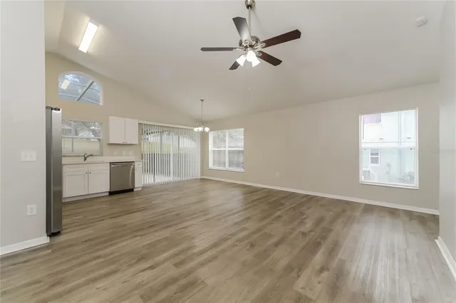 a view of a kitchen with a sink dishwasher cabinets and wooden floor