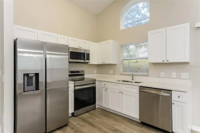 a kitchen with a sink stainless steel appliances and cabinets