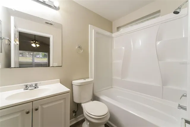 a bathroom with a toilet a sink a mirror a shower and vanity