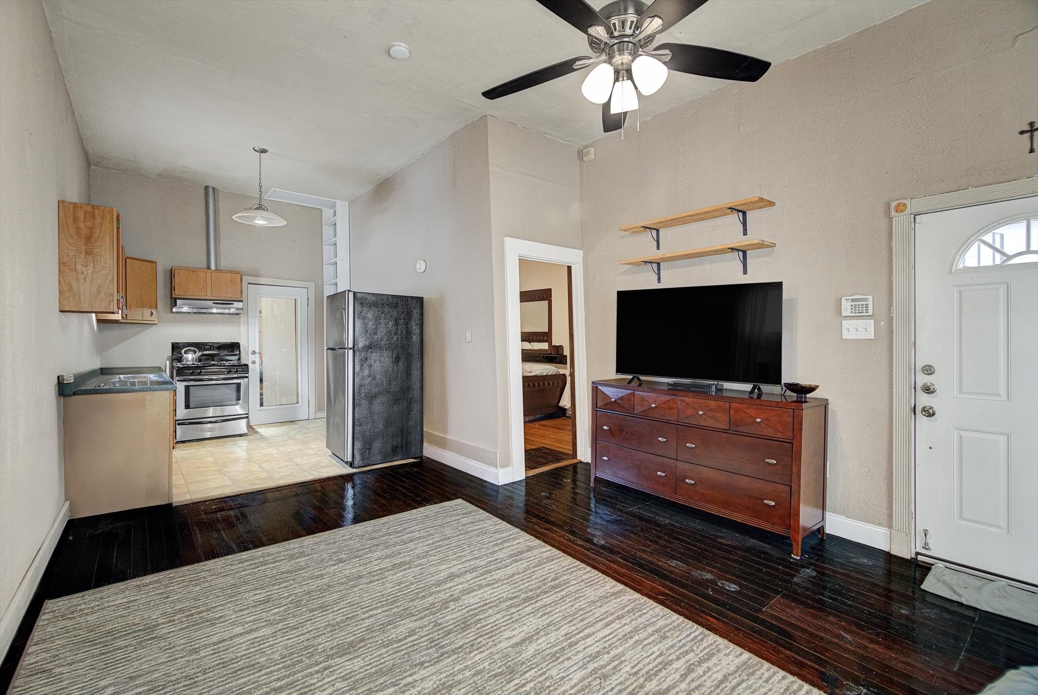 515 Bishop Street Houston, TX 77009 - Photo 4 of 18 a living room with stainless steel appliances furniture a flat screen tv and a refrigerator