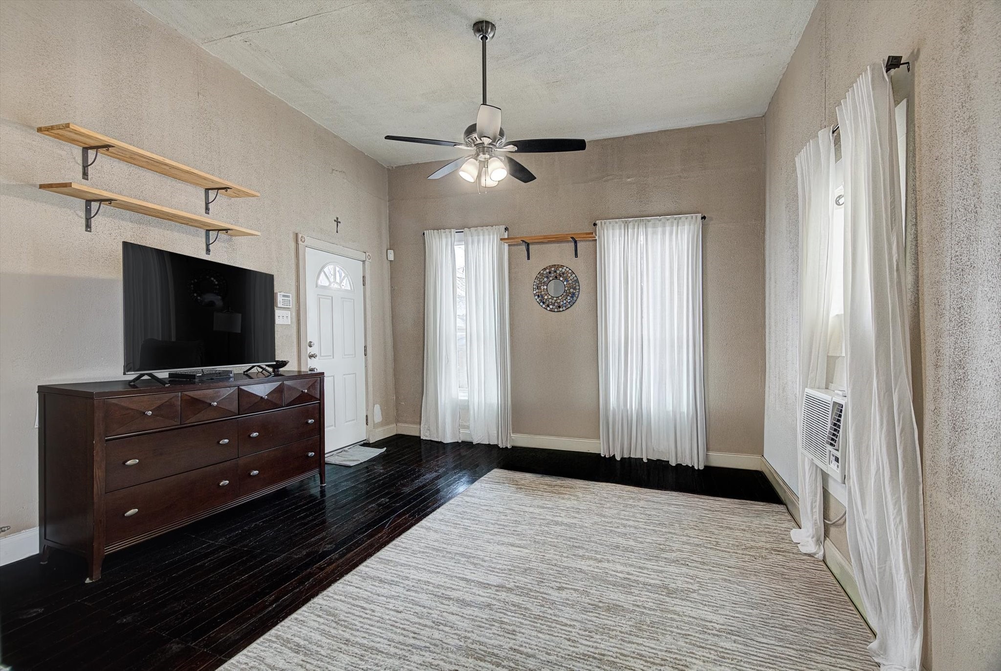 515 Bishop Street Houston, TX 77009 - Photo 5 of 18 a view of a livingroom with a flat screen tv wooden floor and a ceiling fan