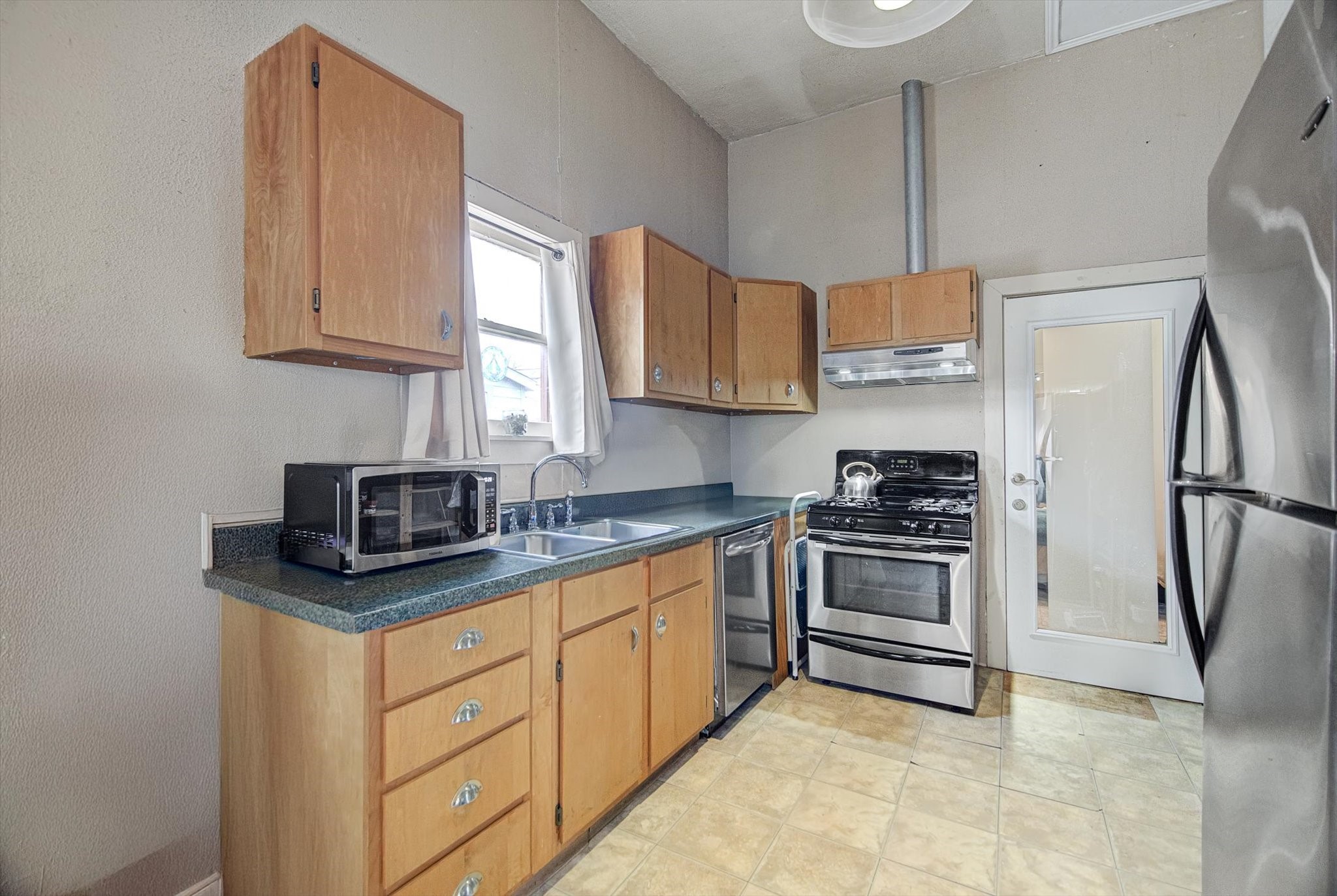515 Bishop Street Houston, TX 77009 - Photo 6 of 18 a kitchen with stainless steel appliances a stove a sink and a refrigerator