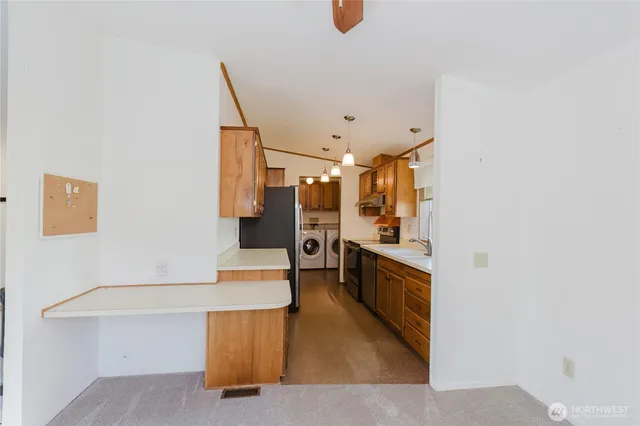 a kitchen with stainless steel appliances kitchen island sink refrigerator and stove
