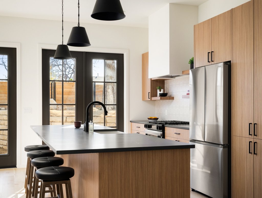 3500 Pecan Springs Road, Unit 9 Austin, TX 78723 - Photo 8 of 40 Quartz counters, pendant lighting and stainless appliances adorn the kitchen.