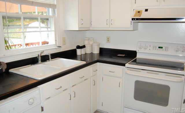The recently remodeled eat-in kitchen features white double sinks,cabinets and appliances. Other