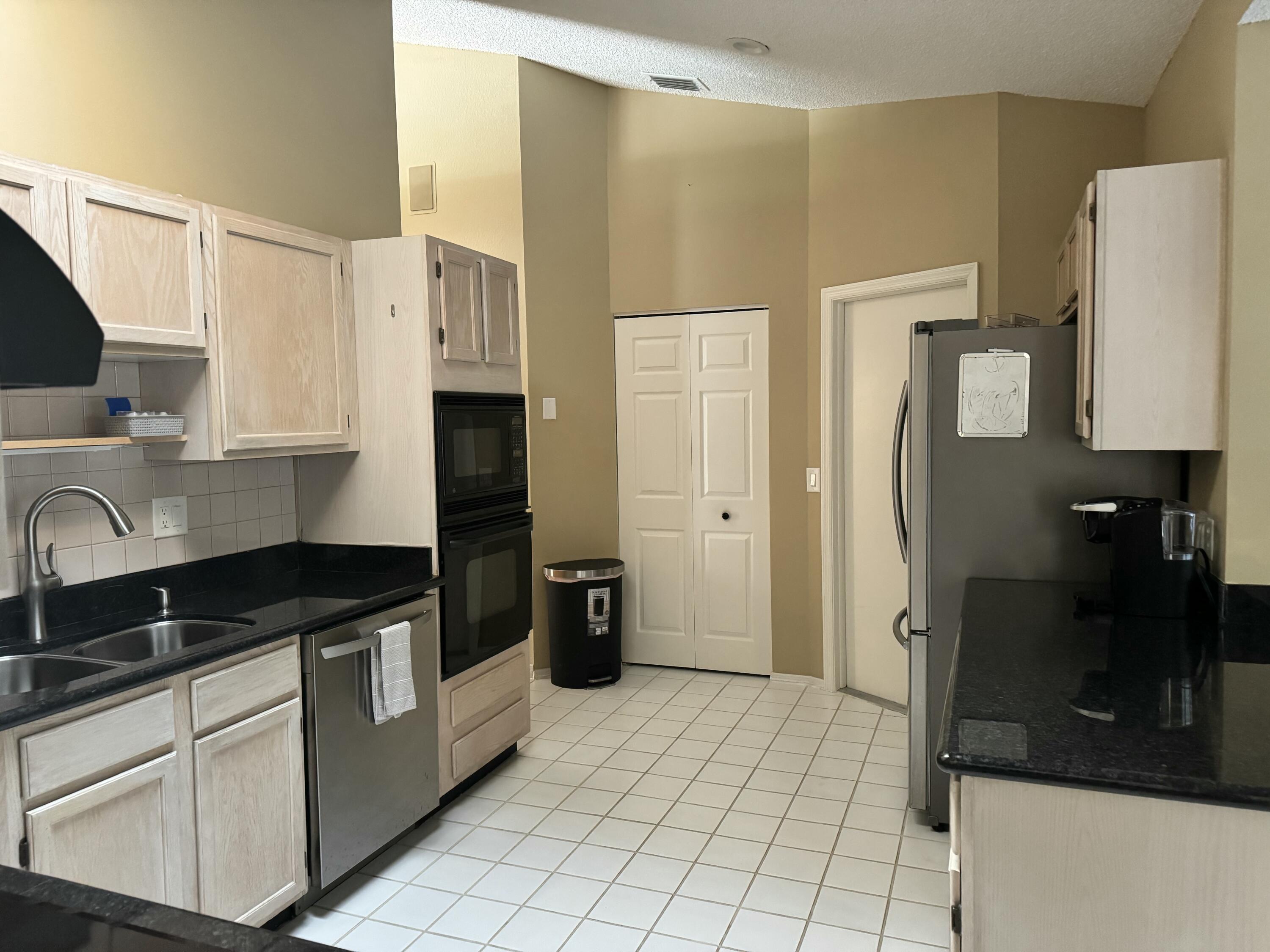 2937 Southeast Cates Circle Port St. Lucie, FL 34952 - Photo 15 of 43 a kitchen with stainless steel appliances a refrigerator sink and cabinets