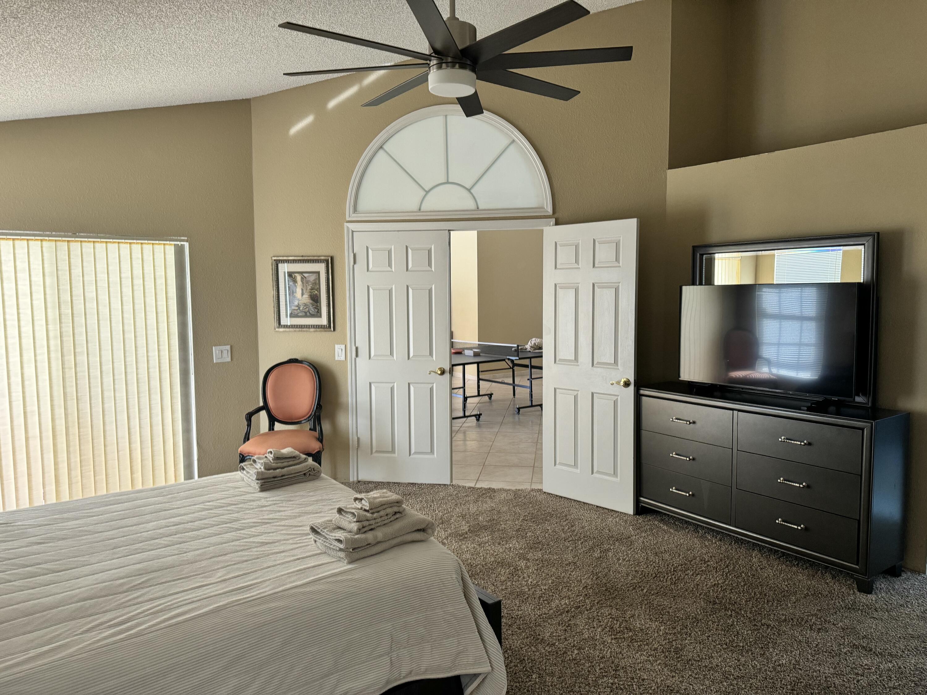 2937 Southeast Cates Circle Port St. Lucie, FL 34952 - Photo 21 of 43 a bedroom with a bed and a flat screen tv