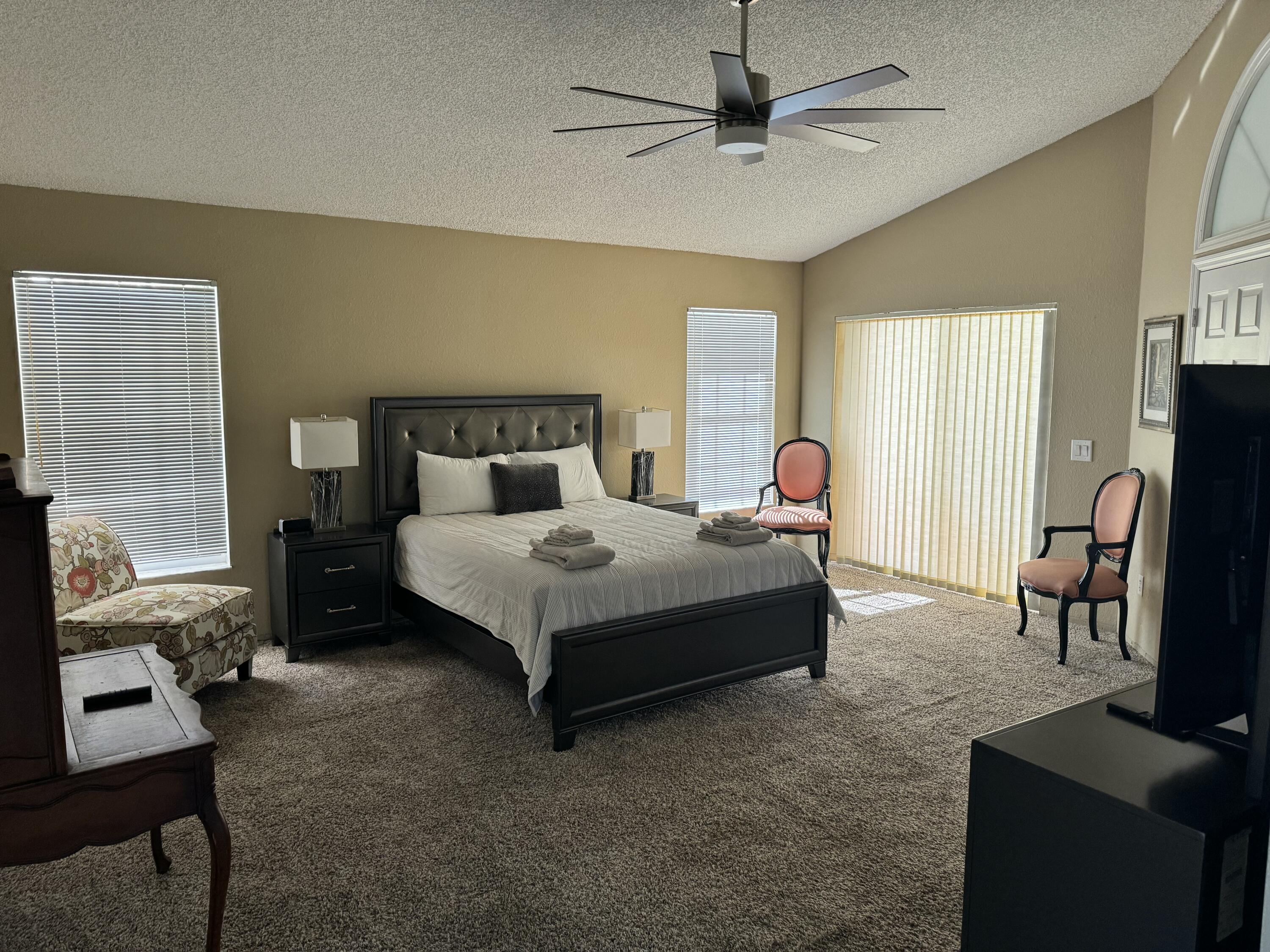 2937 Southeast Cates Circle Port St. Lucie, FL 34952 - Photo 23 of 43 a bedroom with a bed gym equipment and a flat tv screen