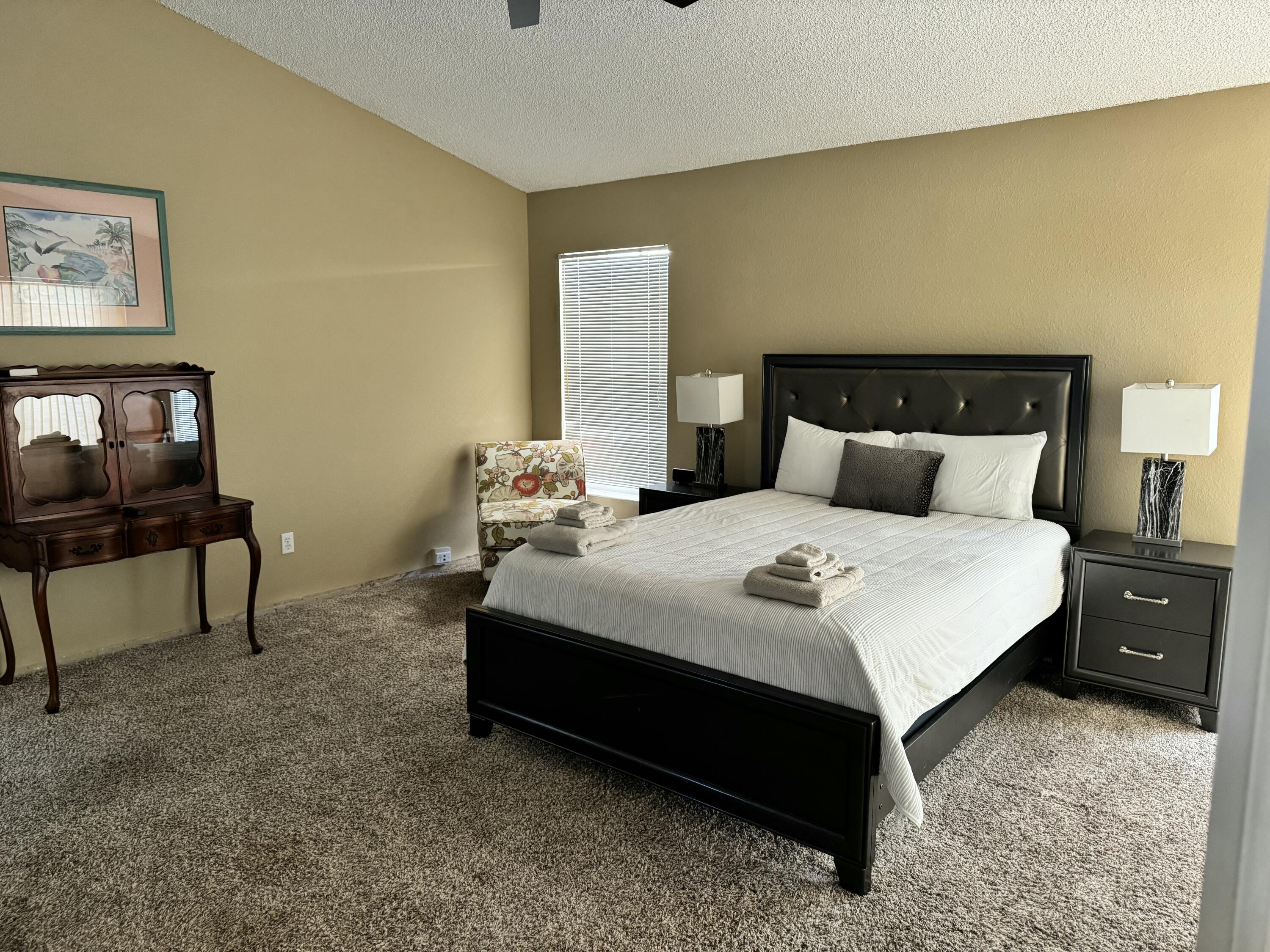 2937 Southeast Cates Circle Port St. Lucie, FL 34952 - Photo 24 of 43 a bedroom with a bed and a table in it