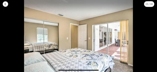 a bed sitting in a bedroom next to a window and dresser