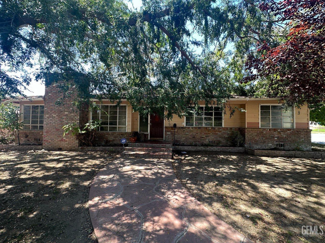 a view of a house with a tree in front of it