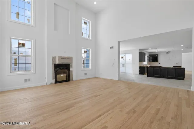 a view of empty room with a fireplace and wooden floor