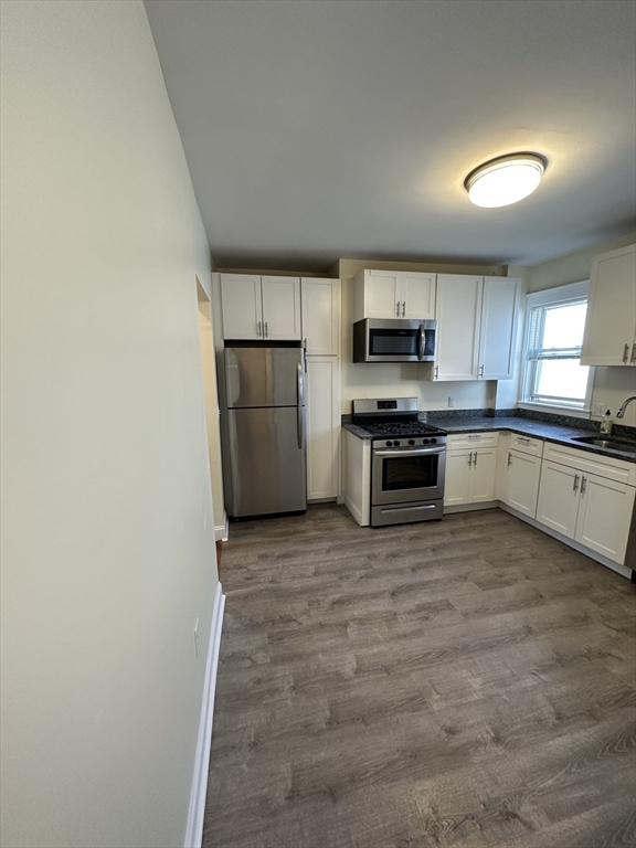 35 George Street, Unit 3 Everett, MA 02149 - Photo 2 of 34 a kitchen with stainless steel appliances granite countertop a stove top oven a sink and a refrigerator