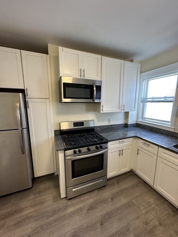 35 George Street, Unit 3 Everett, MA 02149 - Photo 6 of 34 a kitchen with granite countertop a stove a microwave and a sink