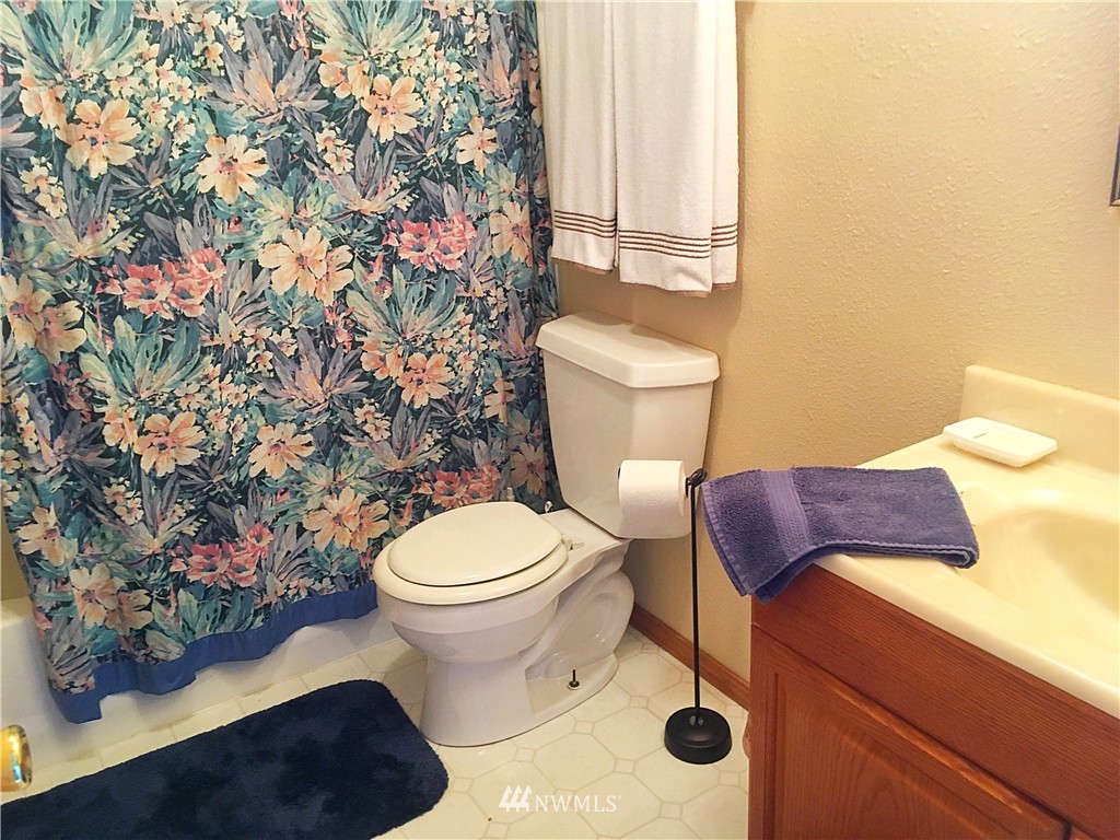 44 Beach Court Decatur Island, WA 98221 - Photo 15 of 25 a white toilet sitting next to a shower curtain
