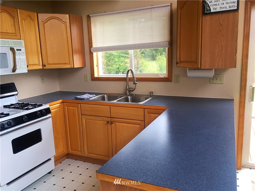 44 Beach Court Decatur Island, WA 98221 - Photo 6 of 25 a kitchen with wooden cabinets and a stove top oven