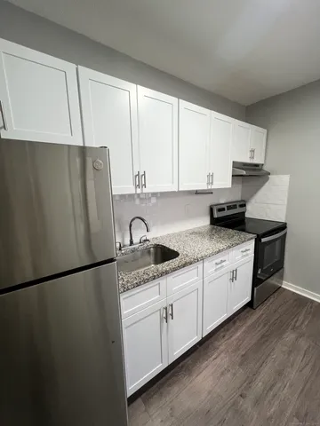 a kitchen with stainless steel appliances granite countertop a refrigerator sink and cabinets