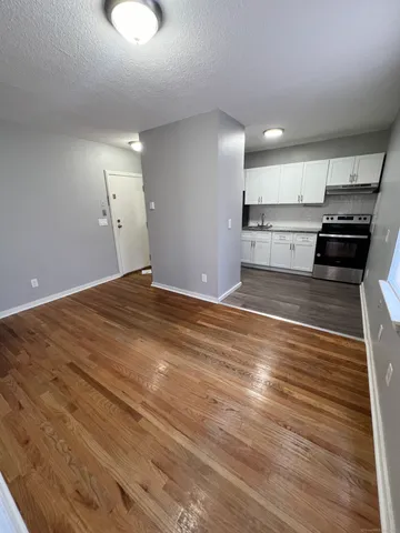 a view of a kitchen with kitchen island a sink wooden floor and electronic appliances