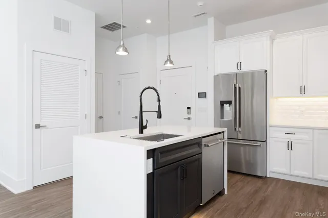 a kitchen with a refrigerator sink and cabinets