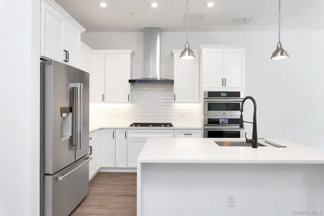 a kitchen with stainless steel appliances a refrigerator and a stove