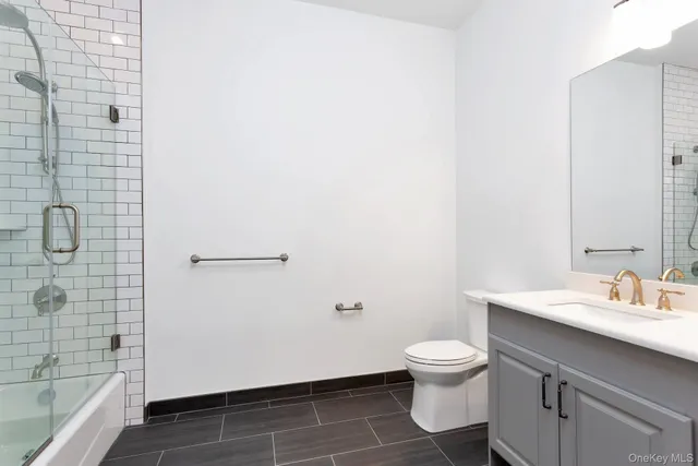 a bathroom with a granite countertop toilet a sink and a shower