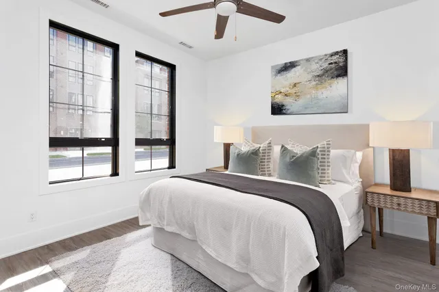 a bedroom with a bed and a lamp on dresser