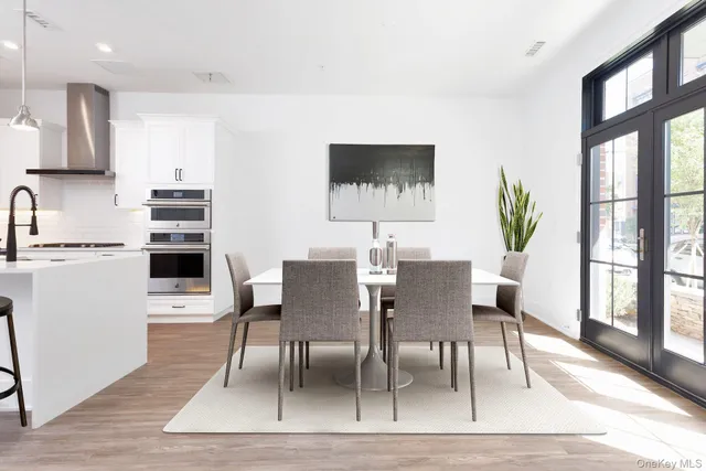 a kitchen with stainless steel appliances a stove a sink a refrigerator and cabinets with wooden floor