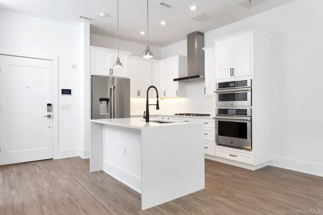 a kitchen with kitchen island a sink stainless steel appliances and cabinets