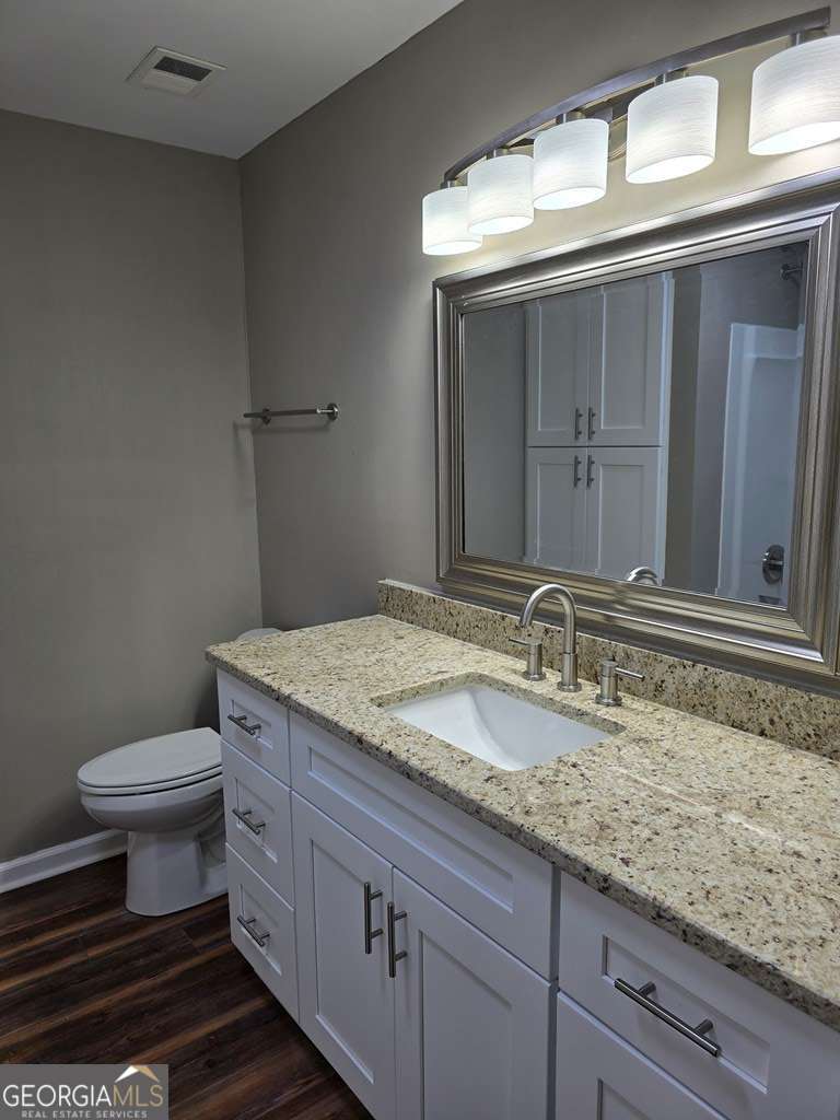 123 Preston Drive Fitzgerald, GA 31750 - Photo 15 of 24 a bathroom with a granite countertop sink a toilet and a mirror