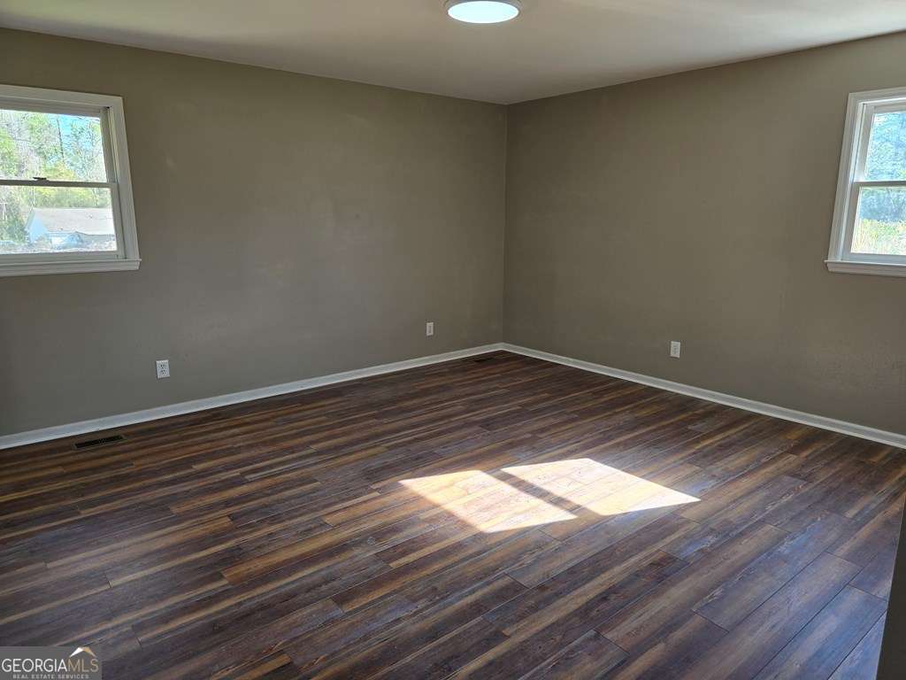 123 Preston Drive Fitzgerald, GA 31750 - Photo 19 of 24 a view of an empty room with wooden floor and a window