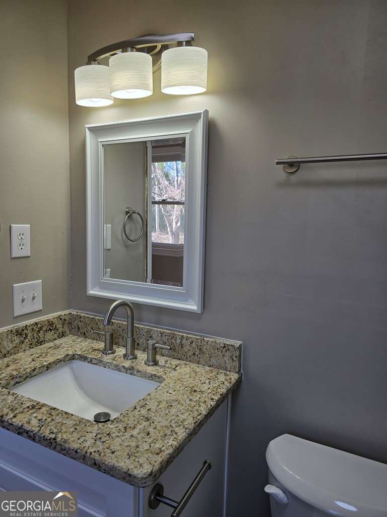 123 Preston Drive Fitzgerald, GA 31750 - Photo 21 of 24 a bathroom with a granite countertop sink and a toilet