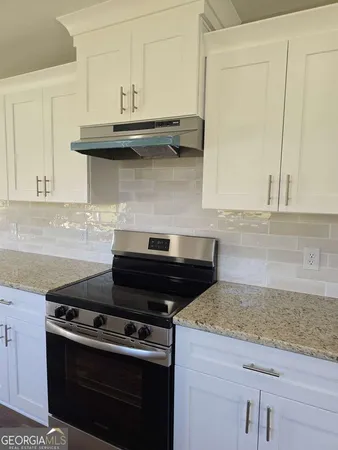 a stove top oven sitting inside of a kitchen