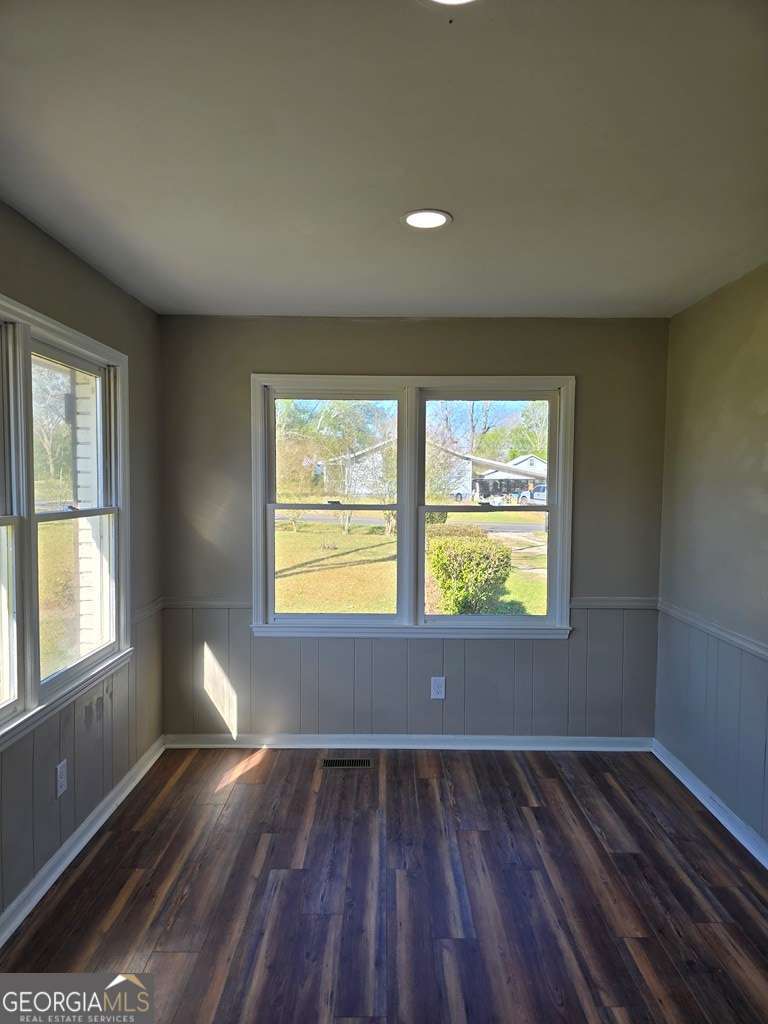 123 Preston Drive Fitzgerald, GA 31750 - Photo 10 of 24 an empty room with wooden floor and windows