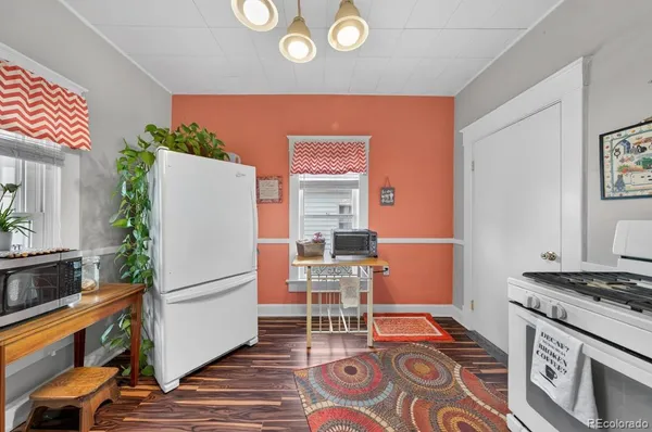 a kitchen with a refrigerator and a stove top oven