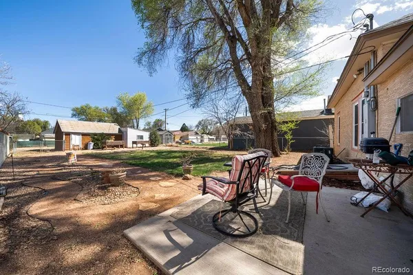 a view of a patio with table and chairs couches under an umbrella with a fire pit