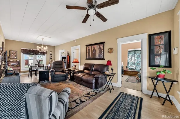 a living room with furniture ceiling fan and a window