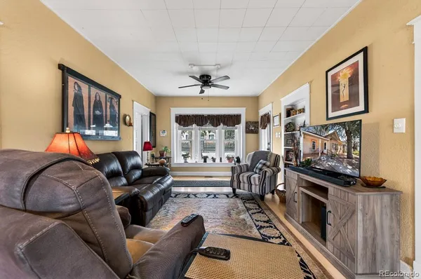 a living room with furniture a flat screen tv and a fireplace