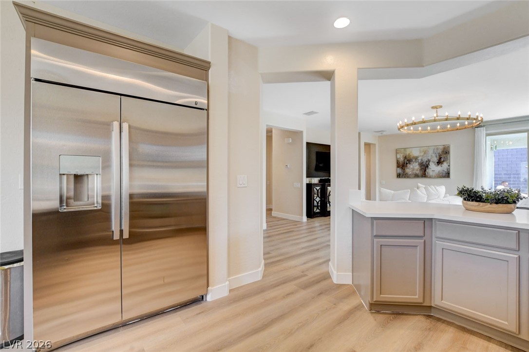2649 Rue Marquette Avenue Henderson, NV 89044 - Photo 23 of 55 This contemporary kitchen features light-toned flooring, a stainless steel refrigerator, and ample counter space, leading to a comfortable living area.