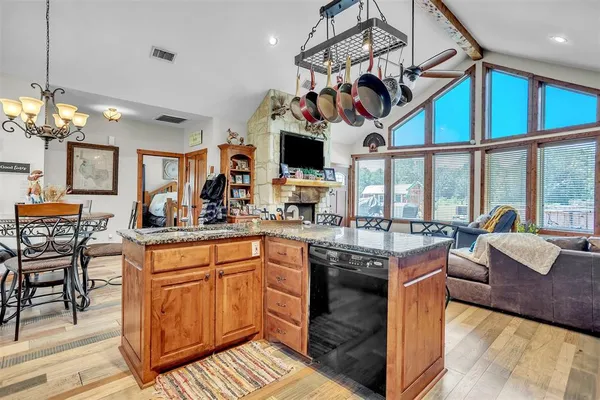 a kitchen with a stove a cabinets and chairs