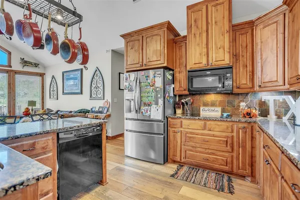 a kitchen with stainless steel appliances granite countertop a stove and cabinets