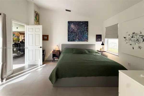 a bedroom with a bed and a large mirror